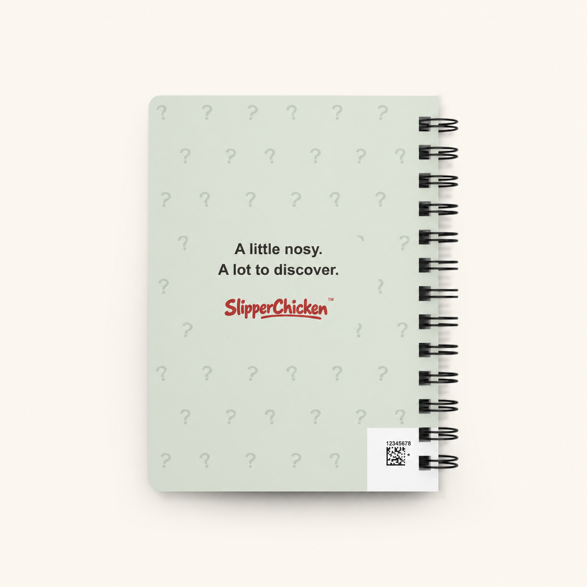Curious Journal light-green back on site tan, with question-mark pattern, SlipperChicken wordmark and visible production barcode.
