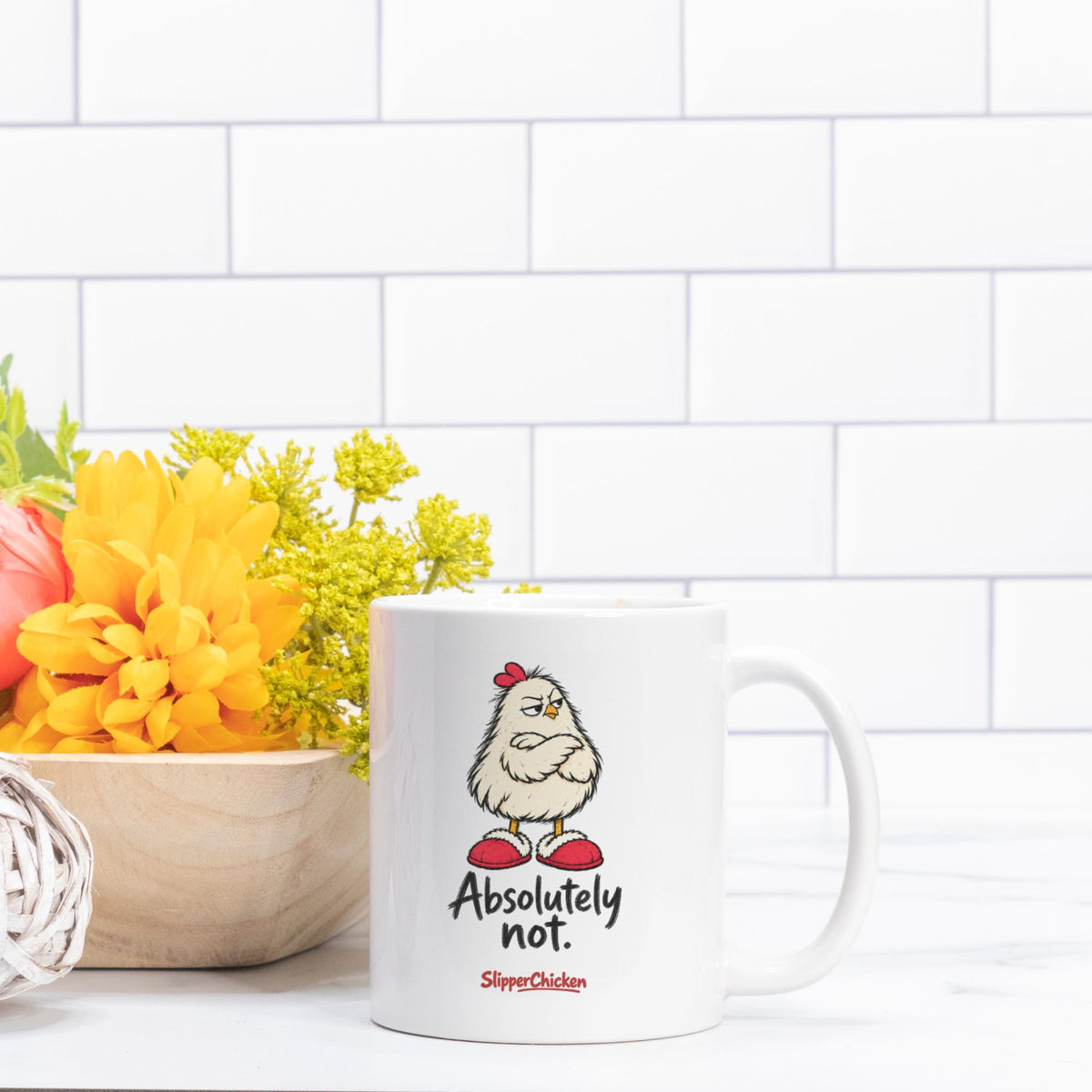 Unimpressed Mug beside yellow flowers against white kitchen tiles